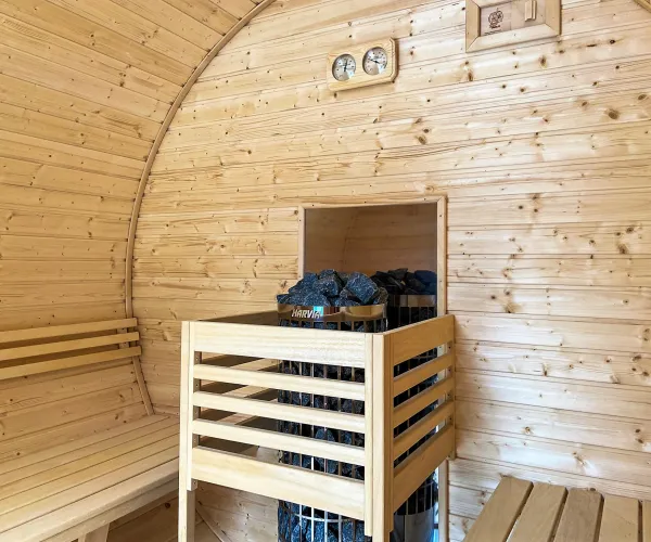 Wooden sauna interior with bench and heater.