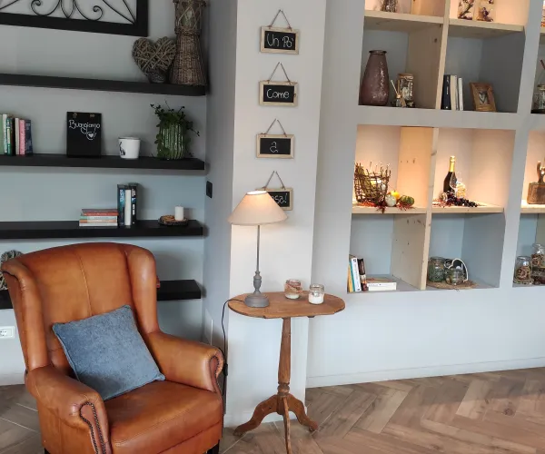 Cozy room with leather armchair, shelves filled with books and decor.