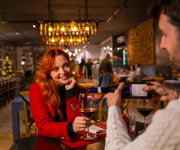 Couple having dinner in a cozy, warmly lit restaurant.