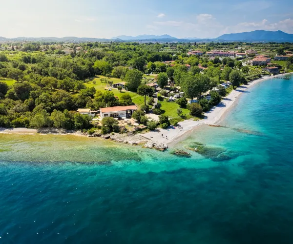 Aerial view of a coastline with turquoise waters and lush green landscape.